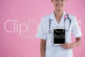 Mid section of smiling female doctor showing tablet computer