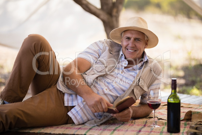 Portrait of happy man reading book in cottage Portrait of happy man reading book in cottage