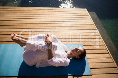 Woman practicing yoga on at poolside