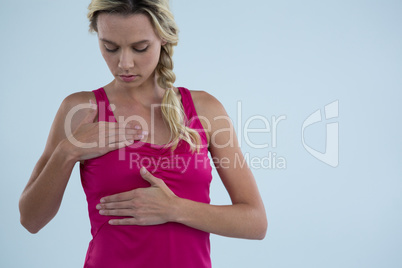 Young woman examining breast for lumps