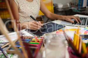 Woman using graphic tablet and laptop in drawing class