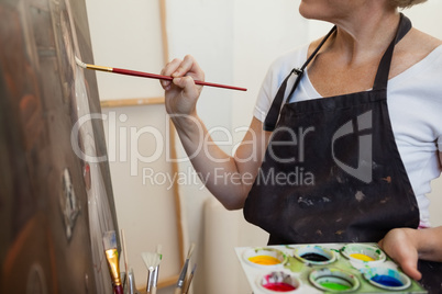 Woman painting on canvas in drawing class Woman painting on canvas in drawing class