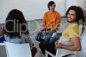 Portrait of smiling man sitting with friends