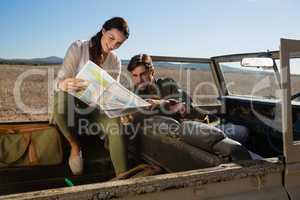 Young couple reading map in off road vehicle