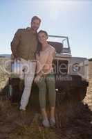 Portrait of couple by parked off road vehicle