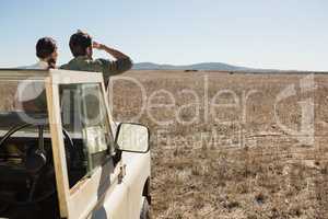 Rear view of couple on off road vehicle looking at landscape