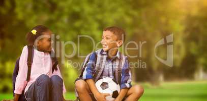 Composite image of boy with friend holding soccer ball