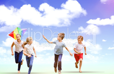 Composite image of full length of boy holding kite running with friends