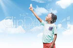 Composite image of child holding paper airplane