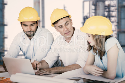 Composite image of architects discussing while sitting at table