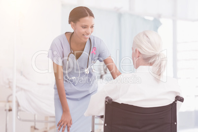 Composite image of smiling nurse assisting female patient in wheelchair