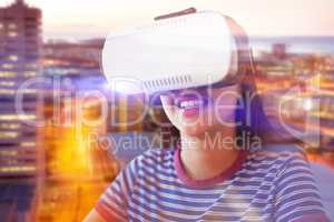 Composite image of happy woman looking through virtual reality simulator