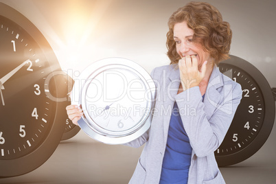 Composite image of worried businesswoman looking at clock