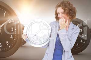 Composite image of worried businesswoman looking at clock