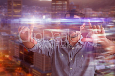 Composite image of businessman gesturing while using virtual reality simulator