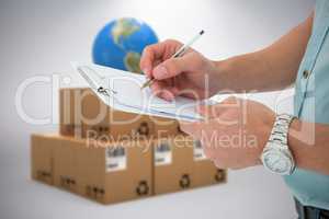 Composite image of delivery man writing on clipboard