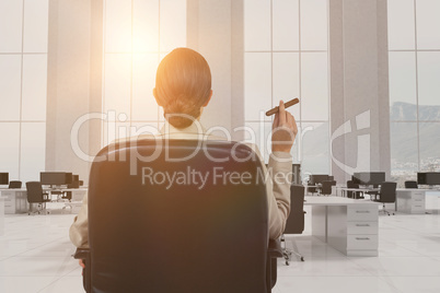 Composite image of rear view of female executive holding cigar