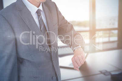 Composite image of mid section of businessman checking smart watch