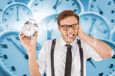 Composite image of geeky businessman holding alarm clock