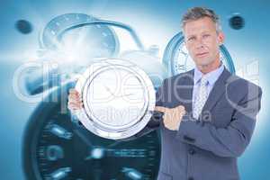 Composite image of portrait of businessman pointing at wall clock