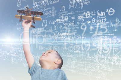 Composite image of boy holding wooden toy airplane