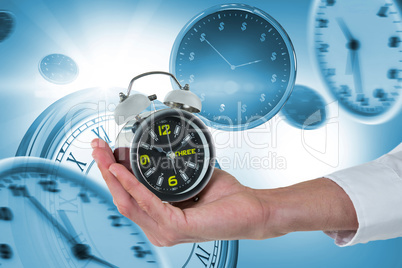 Composite image of cropped hand of male executive holding alarm clock