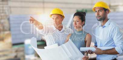 Composite image of architects looking away while holding blueprint