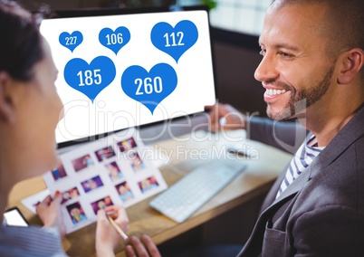 People working on computer in office with likes in heart icons