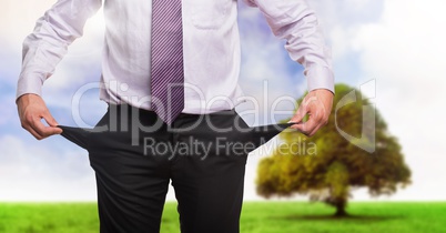 Businessman with empty pockets in nature