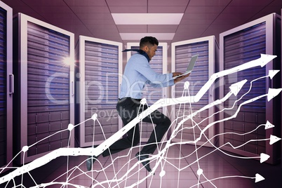 Business man holding a computer and graphics in server room