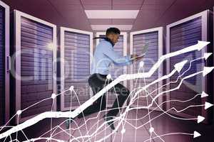 Business man holding a computer and graphics in server room