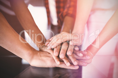 Business people stacking hands on table in office