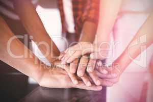 Business people stacking hands on table in office