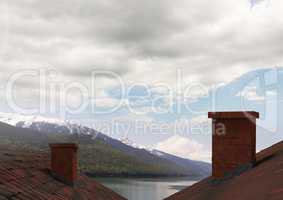 Roofs with chimney and mountain lake landscape