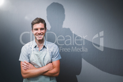 Composite image of portrait of smiling young man standing with arms crossed