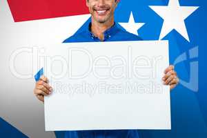 Composite image of portrait of happy man holding placard