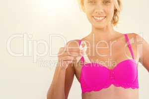 Portrait of woman in pink bra holding ribbon