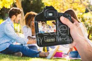 Composite image of cropped hand of photographer holding camera