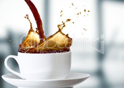 Coffee being poured into white cup against blurry grey office
