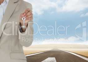 Woman Holding key in front of road