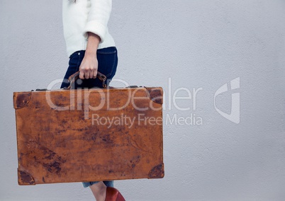 Millennial woman lower body with briefcase against grey wall