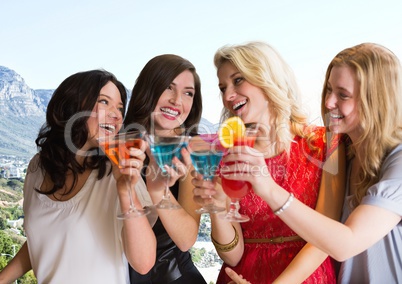 Group of friends with cocktails against blurry coastline