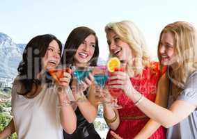 Group of friends with cocktails against blurry coastline