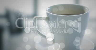White coffee cup and bokeh against blurry grey office