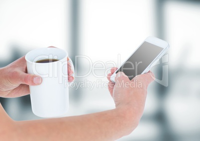 Hands with coffee and phone against blurry grey office