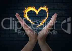 hands with heart fire icon over. Dark bricks wall background