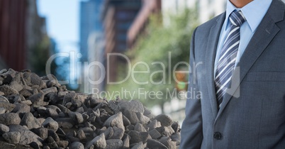 Pile of rubble stone with businessman in city