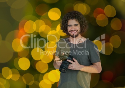 photographer with camera on hands. Green yellow and red bites bokeh background and overlap