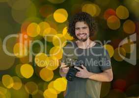 photographer with camera on hands. Green yellow and red bites bokeh background and overlap