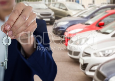 Hand  Holding key in front of cars